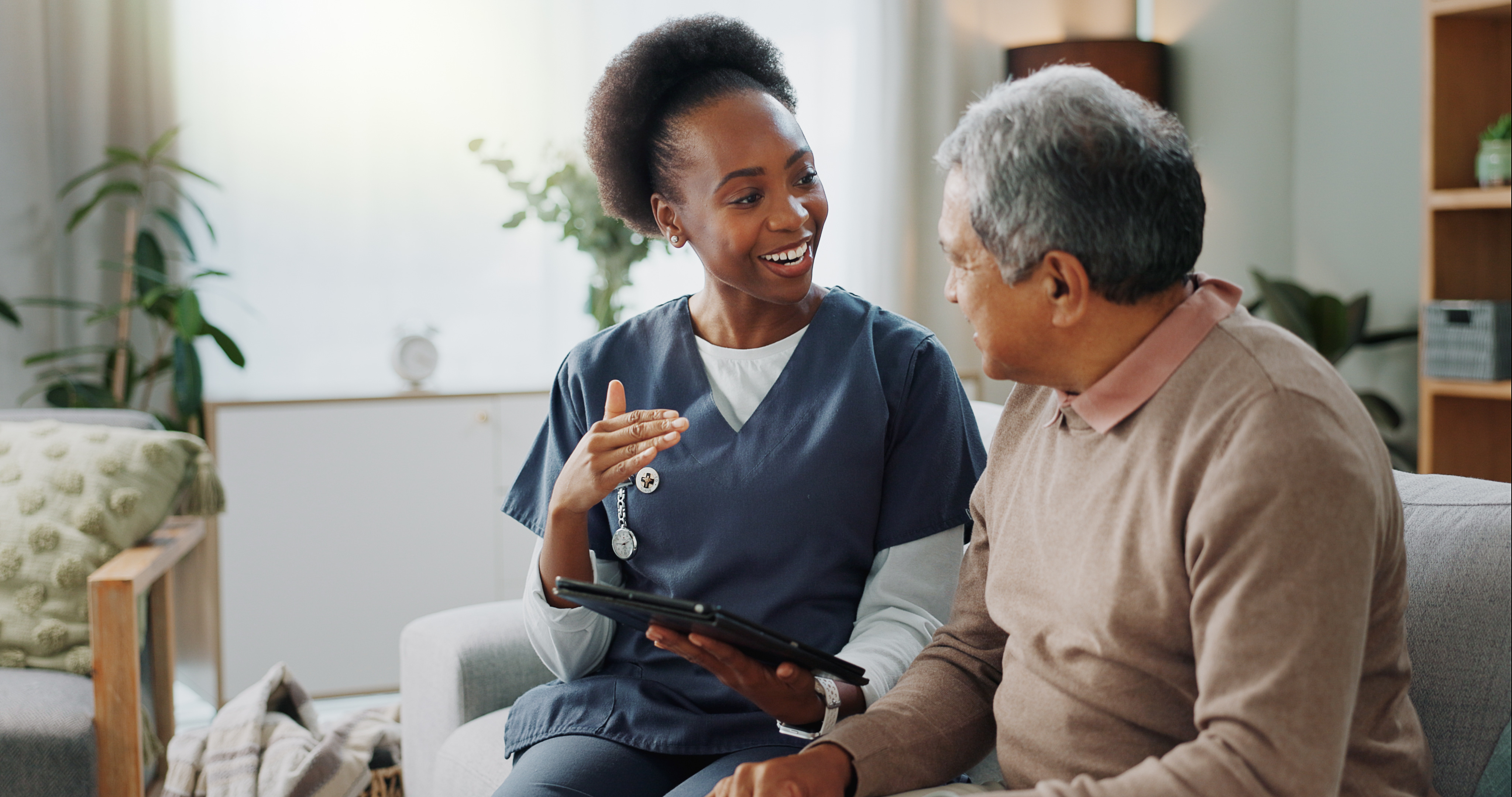 A Pathways clinician reviewing a care plan on a tablet during an in-home visit